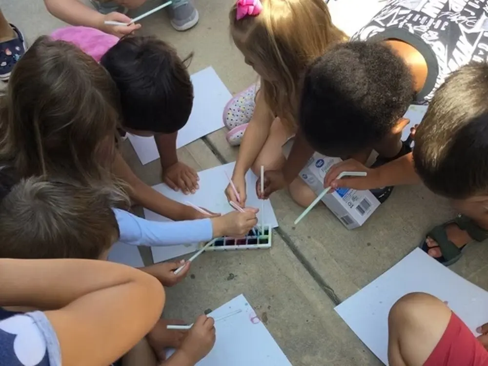 Children painting and drawing together at Happy Days