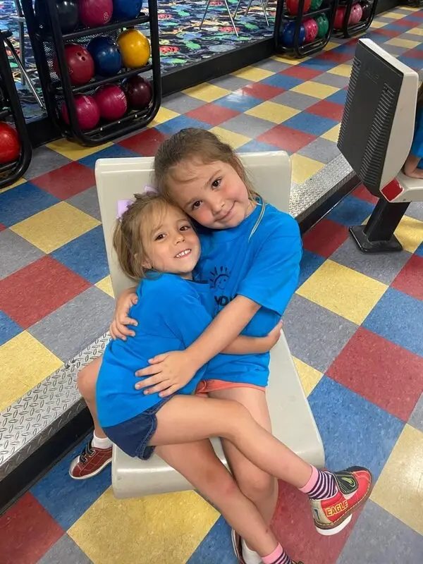 Two Happy Days friends sharing a hug in the classroom